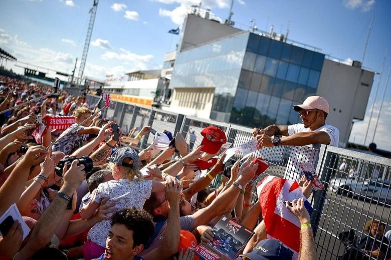 World championship leader Lewis Hamilton signing autographs for fans at the Hungaroring circuit in Mogyorod, north-east of Budapest, on Thursday. The Mercedes driver leads Ferrari's Sebastian Vettel by 17 points.