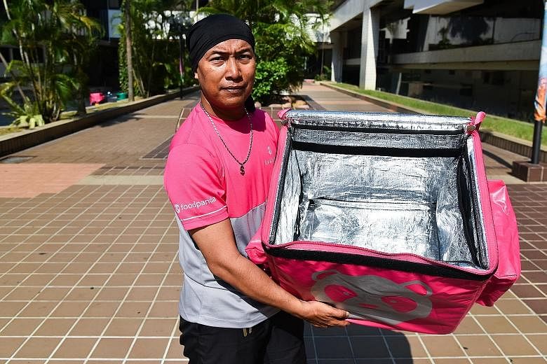 Foodpanda rider Mohamad Azli, 41, shows his delivery bag, which is cleaned and wiped down daily.