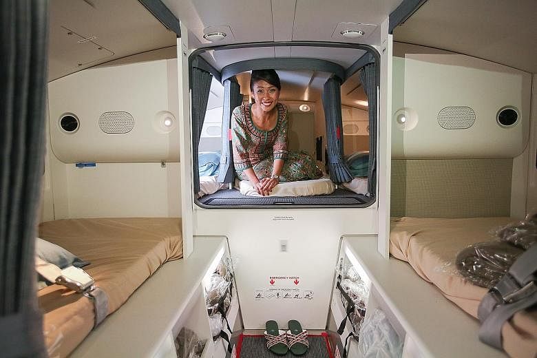 Leading stewardess Ashley Tan shows the bunks where the cabin crew will rest on SIA's A350-900ULR aircraft during the nearly 19-hour flight from Singapore to Newark. Stewardesses will change out of their kebayas and some may undo their hair to sleep.