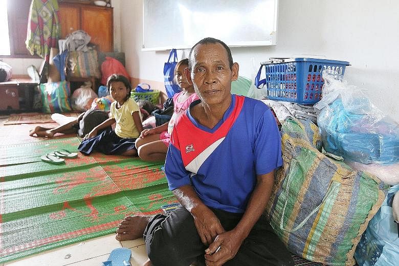 Mr Phon, 70, in a classroom at Sanamxai Secondary after his rescue. The farmer lost many of his prized possessions in the dam collapse, including his buffaloes, a small box containing the family's meagre jewellery collection, and his home.