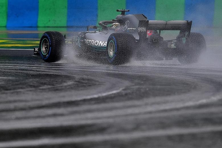 Mercedes driver Lewis Hamilton steering his car on the wet track at the Hungaroring circuit in Mogyorod near Budapest during the qualifying session yesterday.