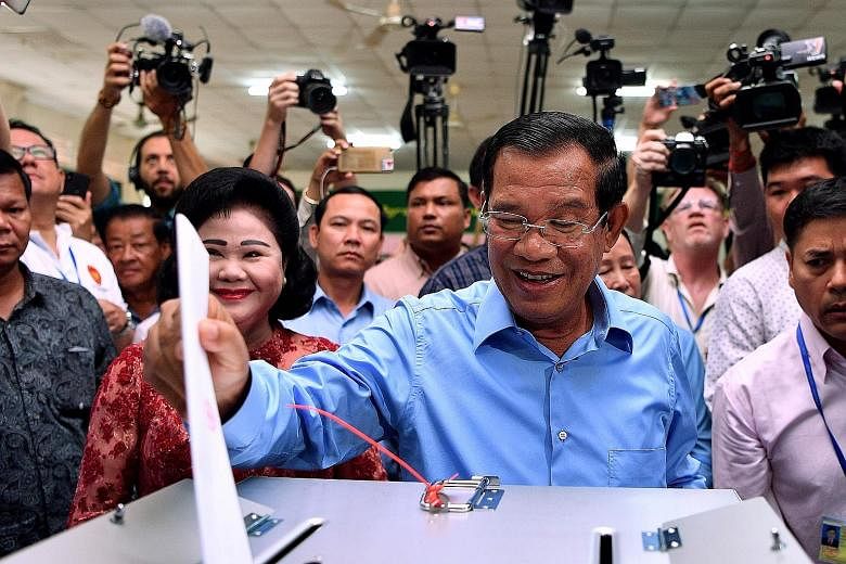 Caretaker Prime Minister Hun Sen casting his vote at a polling station in Phnom Penh yesterday, with his wife Bun Rany by his side.