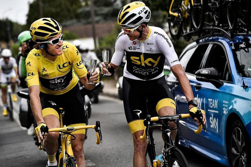 Geraint Thomas in the overall leader's yellow jersey sharing some champagne with his Sky team-mate and last year's Tour winner Chris Froome on the 21st and final stage from Houilles to Paris yesterday.