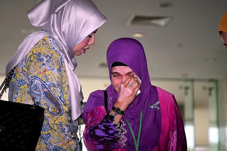A woman who lost two family members in the MH370 incident crying after a briefing on the report.