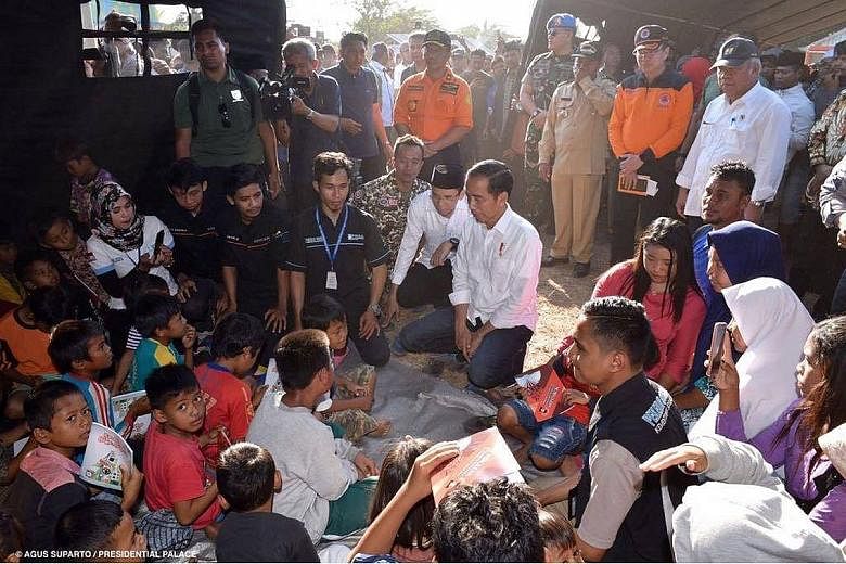 President Joko Widodo visiting victims at a makeshift shelter in Sambelia district, Lombok, yesterday. He assured them that the government will provide aid to residents whose homes were destroyed.