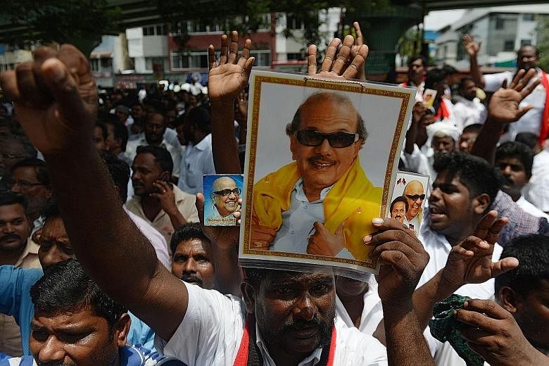 Supporters display portraits of DMK leader M. Karunanidhi in front of the hospital where he is being treated.