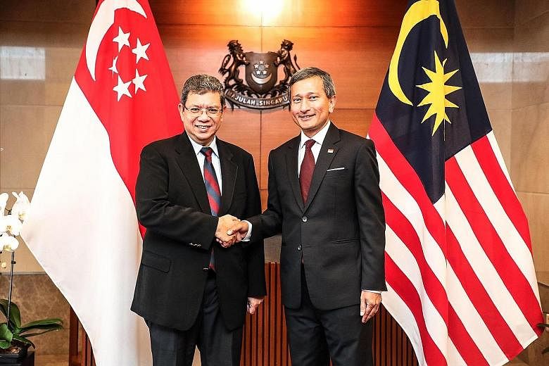 Above: Datuk Saifuddin meeting President Halimah Yacob yesterday, where she expressed Singapore's commitment to strengthen bilateral ties with Malaysia. Right: Mr Saifuddin with Foreign Minister Vivian Balakrishnan. They discussed ways to boost bilat
