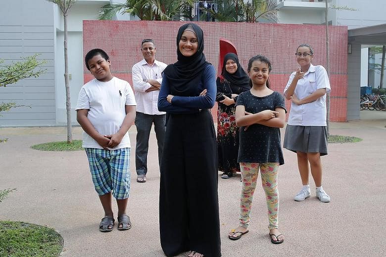 Ms Aliyah Fathin Sirajul Islam (centre) was a mother figure to (from left) her brother, Alman Safwan, 10, and sisters, Aliyah Tsara', nine, and Aliyah Maisarah, 13, while her parents, Mr Sirajul Islam and Madam Sapiah Haron, were busy rebuilding thei