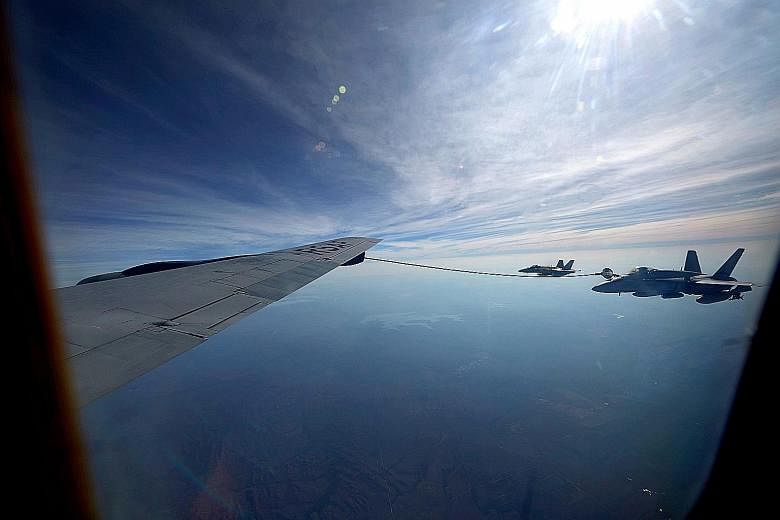 Above: The Republic of Singapore Air Force's (RSAF) KC-135 refuelling a Royal Australian Air Force plane. Right: RSAF engineers preparing an F-16C/D fighter aircraft for operations.