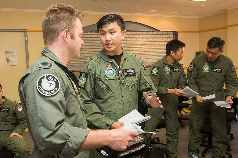 Captain Janzen Koh, a mission leader, discussing strategy with another leader from the Royal Australian Air Force's flight team. About 330 personnel from the RSAF are taking part in the largest operation of Exercise Pitch Black.