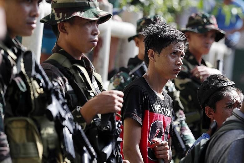 Filipino soldiers standing guard on a street in Manila on Wednesday, following a suicide attack the day before at an army checkpoint on Basilan island, a militant stronghold some 1,000km south of the Philippine capital. The blast instantly killed a s
