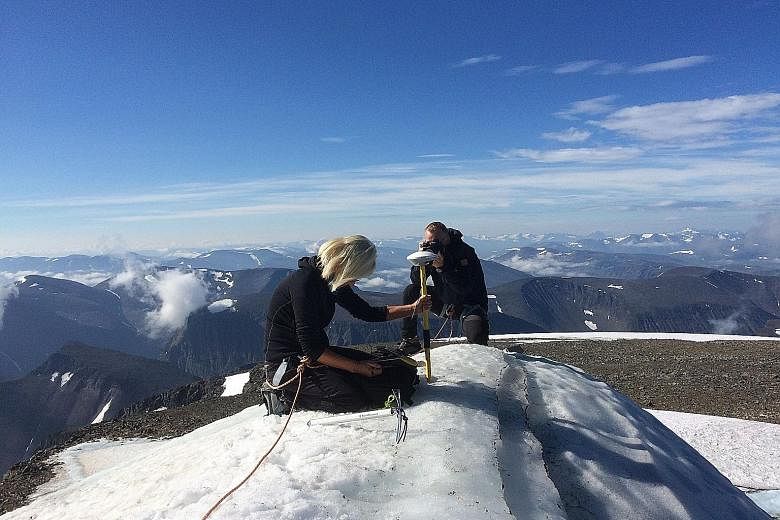 Stockholm University geography professor Gunhild Ninis Rosqvist making measurements on Tuesday atop a glacier on the southern tip of the Kebnekaise mountain in northern Sweden, which is melting due to record hot Arctic temperatures.