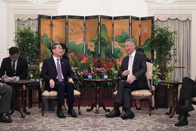 Left: Chinese Foreign Minister Wang Yi with Prime Minister Lee Hsien Loong at the Istana yesterday. They discussed key issues including the importance of maintaining stable Sino-US ties. Right: US Secretary of State Mike Pompeo calling on PM Lee yest