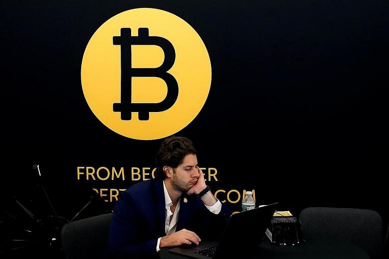 Bitcoin - with its logo seen here at the Consensus 2018 blockchain technology conference in New York City in May - is not discovered or created by "miners". Rather, they get new coins as a reward for securing the network.