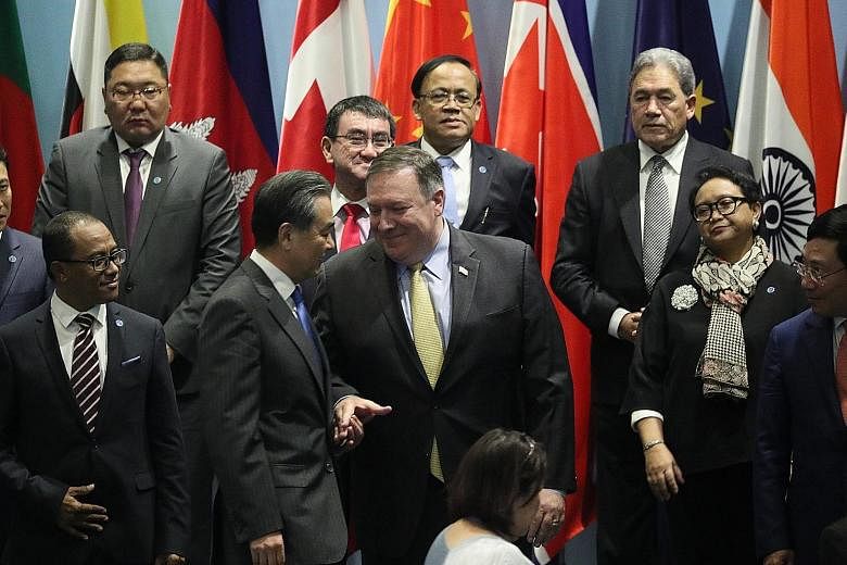 US Secretary of State Mike Pompeo shaking hands with Chinese Foreign Minister Wang Yi at the East Asia Summit foreign ministers' meeting yesterday. The 25th Asean Regional Forum Retreat session being held at the Singapore Expo yesterday.