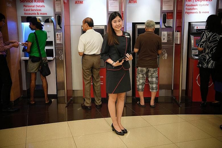 OCBC's Miss Aisha Poh Zi Qian was unfazed by the bank's plan to halve the number of its bank teller jobs over two years. In March, she was among the first batch of 16 to be retrained as digital ambassadors.