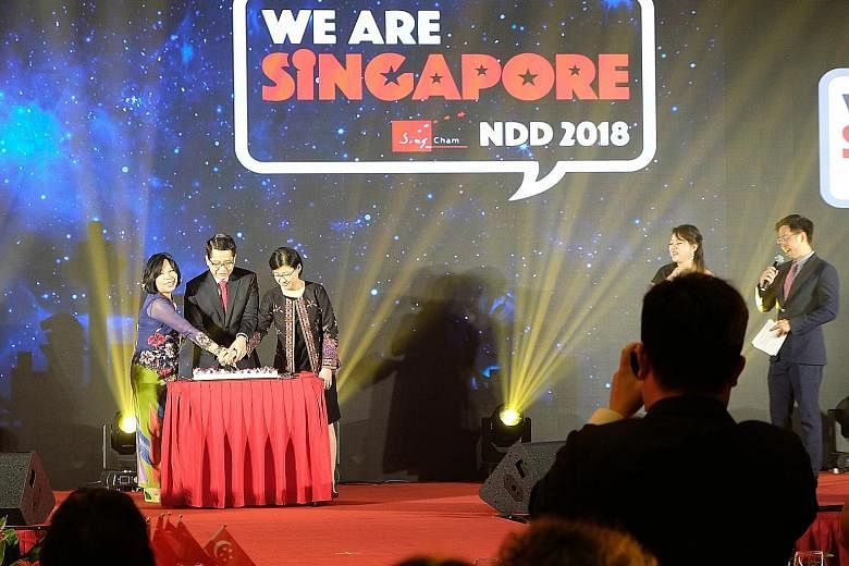 SingCham chair Dorothy Seet (left), Singapore's Ambassador to China Stanley Loh and his wife Kim Loh cutting a birthday cake at the chamber's National Day Dinner.