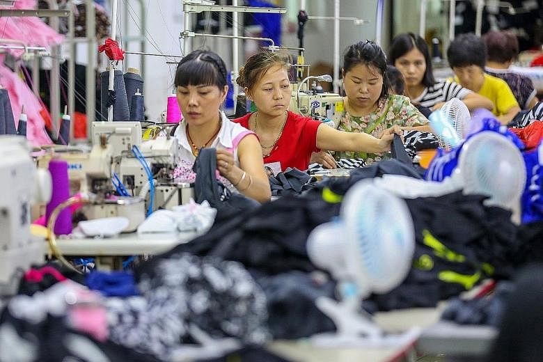 Workers at a swimwear factory in Jinjiang, in China's eastern Fujian Province. Speaking on the sidelines of a regional forum in Singapore yesterday, Chinese State Councillor and Foreign Minister Wang Yi said that China's threat of retaliatory tariffs