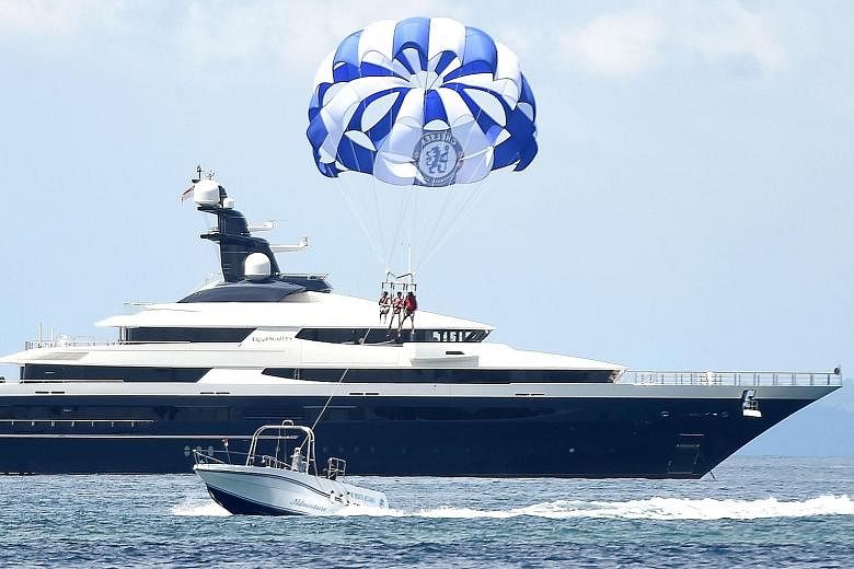 The luxury yacht Equanimity (left) was allegedly purchased with funds embezzled from scandal-ridden 1MDB. The vessel is allegedly owned by fugitive financier Jho Low.