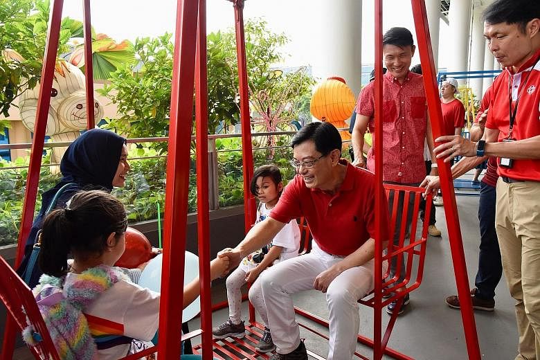 Finance Minister and Tampines GRC MP Heng Swee Keat greeting a family on a swing at the All-Inclusive Playground in Our Tampines Hub yesterday. Rock climbers attempting to complete a 53km rock wall climb yesterday at the Rock School in Our Tampines H