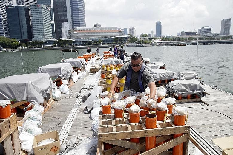 Top and above: During the NDP Preview on Sunday, fireworks lit the sky in the daytime and at night. Right: Workers preparing fireworks for an NDP rehearsal.