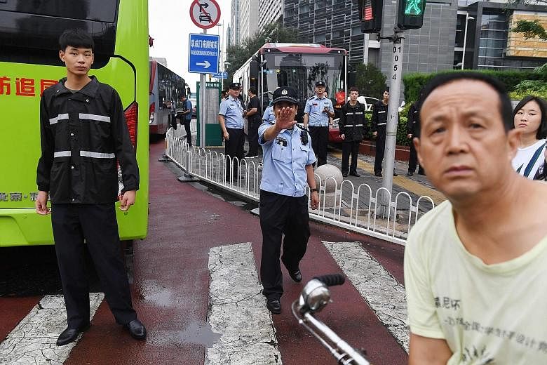Police officers in front of the China Banking Regulatory Commission yesterday, as petitioners from all over China planning to protest against losses sustained on peer-to-peer lending platforms were loaded into buses and driven away under police escor