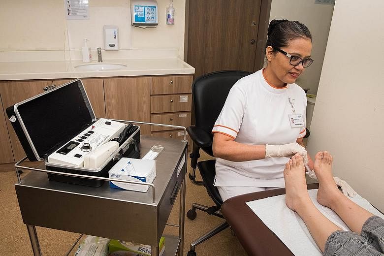 Ms Rubiah Omar, a senior enrolled nurse at Bukit Batok Polyclinic under the National University Polyclinics, conducting a foot screening with the aid of the 10g monofilament device. At the National Healthcare Group, the polyclinics under its charge h