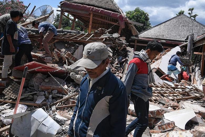 Rescuers searching for survivors yesterday. Many are struggling to reach those trapped in the rubble of collapsed buildings on Lombok. The quake has killed 105 people, including two in neighbouring Bali, and injured more than 230 others.