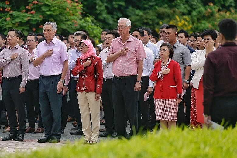 President Halimah Yacob, flanked by PM Lee Hsien Loong and ESM Goh Chok Tong, reciting the Singapore Pledge with 400 staff members of the Istana, Prime Minister's Office, Military Police Command and NParks at a National Day Observance Ceremony yester