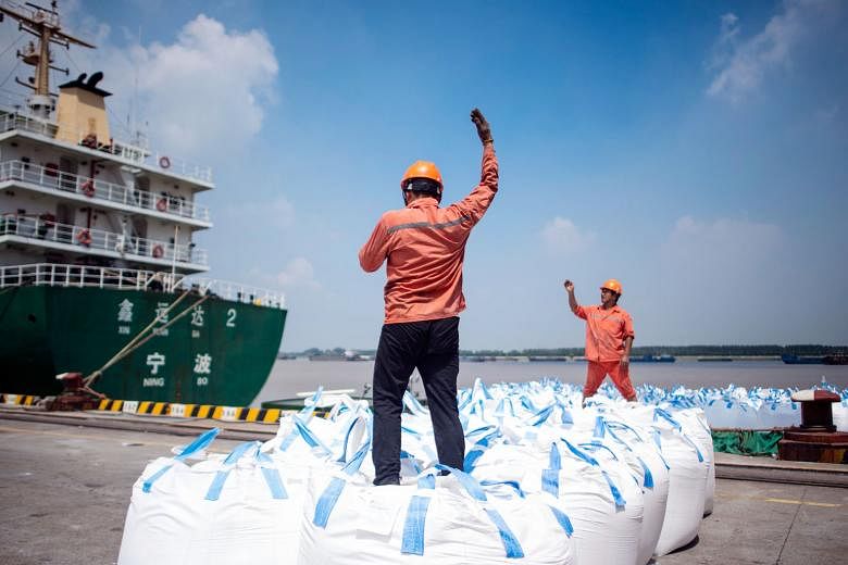 Workers unloading cargo at a port in Zhangjiagang in Jiangsu province. Washington is set to begin collecting 25 per cent tariffs on another US$16 billion (S$21.8 billion) in Chinese goods on Aug 23.