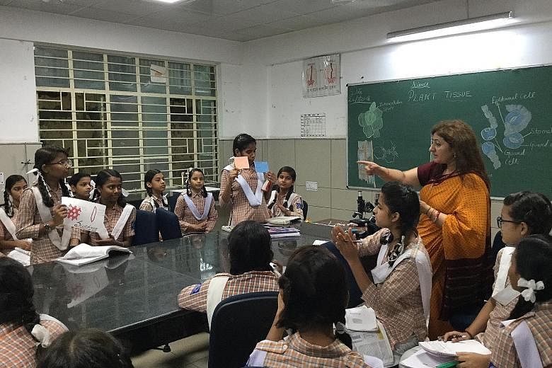 Ninth grade students from Mandawali's Sarvodaya Kanya Vidyalaya No. 2, a government-run school, engage in a group discussion with their science teacher. The use of learning techniques like group discussions is part of a radical shift under way in Del