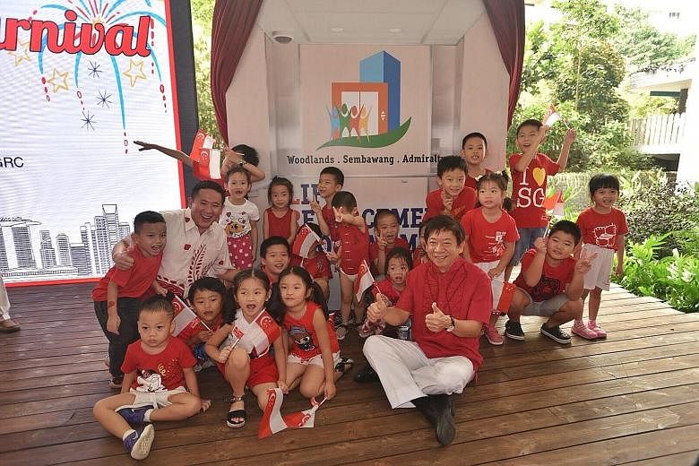 Sembawang GRC MPs Khaw Boon Wan (in red shirt) and Amrin Amin (in white shirt) at a National Day event held at Kampung Admiralty yesterday to launch the lift-replacement programme.