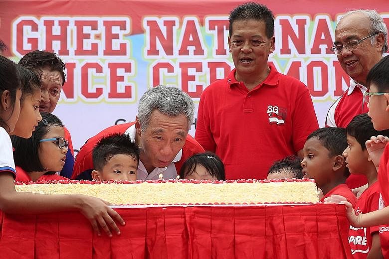 Prime Minister Lee Hsien Loong blowing out candles on a cake together with children from the PAP Community Foundation at the Teck Ghee National Day observance ceremony yesterday. On Mr Lee's left are Mr Dee Kim Hua, organising chairman of the ceremon