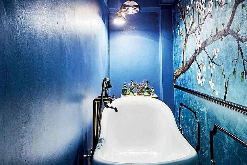 (Far left) Furniture with Oriental details, such as lacquer finishes, adorns the five-room flat. (Left) A freestanding claw-foot tub and handprinted floral mural create an old-world vibe in the bathroom. While the home owners have retained the marble