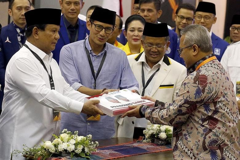 Presidential candidate Prabowo Subianto (left) and running mate Sandiaga Uno (beside him) filing their papers in Jakarta yesterday. With them is Prosperous Justice Party chairman Sohibul Iman (second from right).