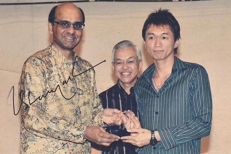 Mr Kim receiving a Taman Jurong commendation award for community service in 2009 from Deputy Prime Minister Tharman Shanmugaratnam, who also signed this picture for him.
