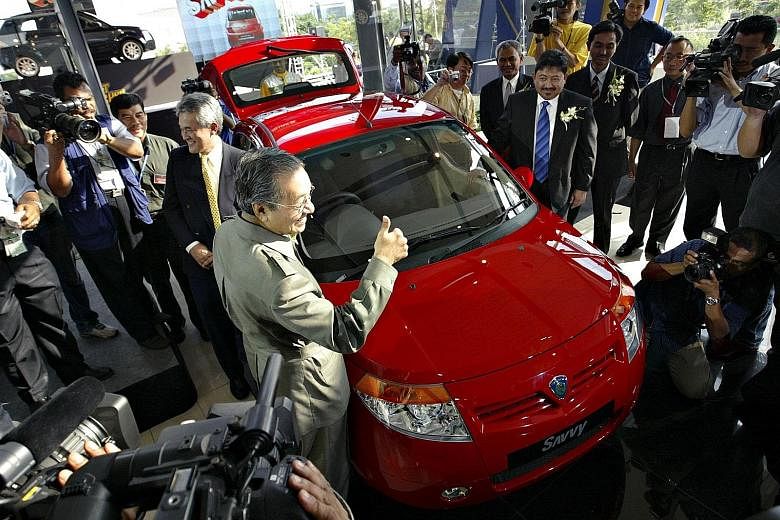 Tun Dr Mahathir Mohamad giving a thumbs up at the launch of the then new model Proton Savvy on June 8, 2005. The Proton national car project, Malaysia's first, was launched by Dr Mahathir in 1983. Perodua, the second national car project, was establi