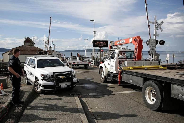 Aircraft retrieval vehicles (left) arriving last Saturday at the Steilacoom ferry dock for the trip to Ketron Island, the crash site of the Horizon Air plane that was stolen from Sea-Tac International Airport in Seattle, Washington. The empty airplan