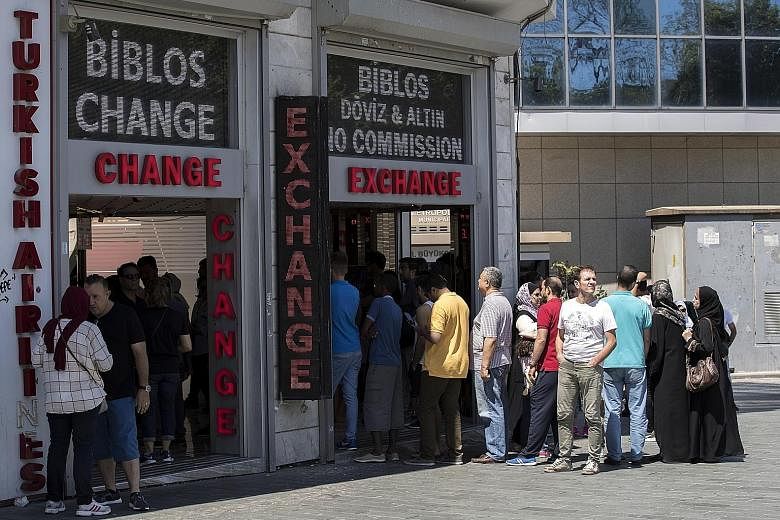 A currency exchange office in Istanbul, Turkey, yesterday. Turkey's lira rebounded yesterday from record lows after the central bank pledged to provide liquidity and cut reserve requirements for banks, but the currency was still down around 10 per ce