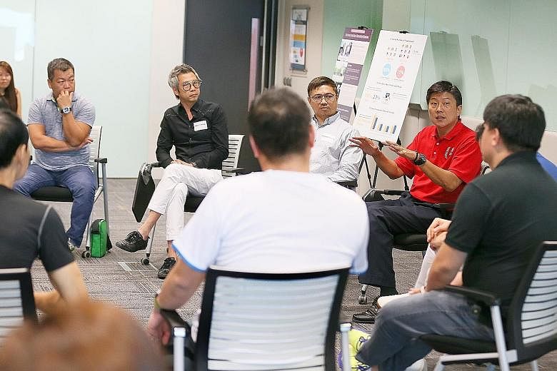 NTUC secretary-general Ng Chee Meng (in red) at a dialogue session with the working committee for the formation of the National Instructors and Coaches Association at the NTUC Centre yesterday. Membership is open to coaches and instructors in industr