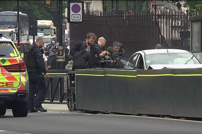 Forensics officers examining evidence around the silver Ford Fiesta that was driven into a barrier at the Houses of Parliament yesterday. Three people were injured in the attack. TV footage showing the arrest of a handcuffed driver in his late 20s ou