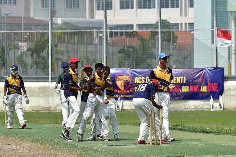 Anglo-Chinese School (Independent) bowler Pranav Nitin Maheshwari (being hugged), 13, celebrates after running out a Raffles Institution batsman during the Schools National C Division cricket final yesterday at the Ceylon Sports Club. ACS (I) beat ar