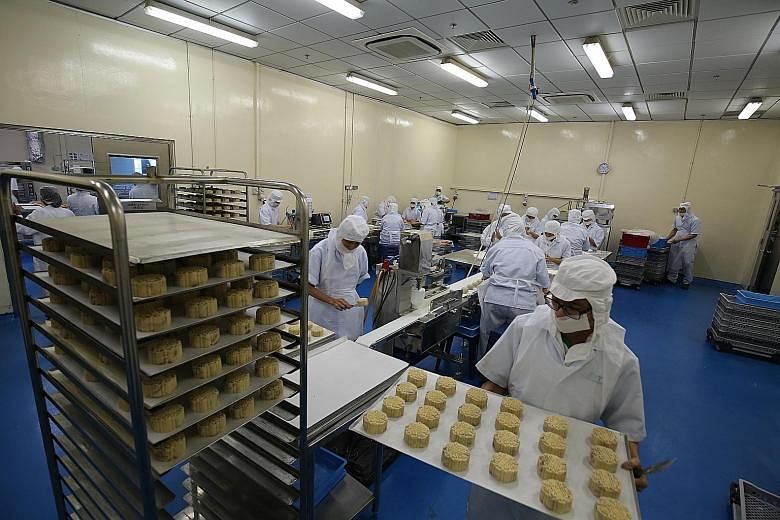 Workers at TungLok's production facility in Sembawang. About 80 per cent of the mooncakes sold at its restaurants are now lower in sugar.