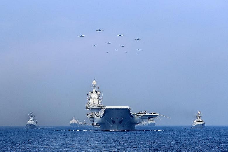Chinese warships and jets taking part in a military display in the South China Sea in April.
