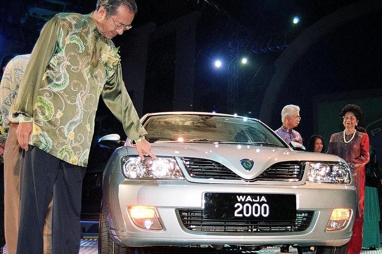Dr Mahathir inspecting a newly launched Proton Waja in Shah Alam, Malaysia, in 2000. Dr Mahathir receiving a Japanese national football jersey from his Japanese counterpart, Mr Shinzo Abe, in Tokyo in June. Dr Mahathir wants to increase Malaysia's pr