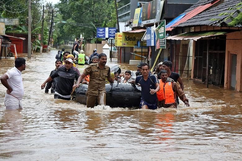 Rescuers evacuating people from a flooded area in Aluva, Kerala, yesterday. Some of the victims have reached out to their families and friends in Singapore for help. Mr Rajesh Chandran (far left)with his family at the family home in Kerala last year.