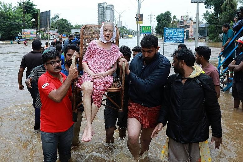 Volunteers and rescue workers evacuating a flood victim in the Indian state of Kerala on Friday.