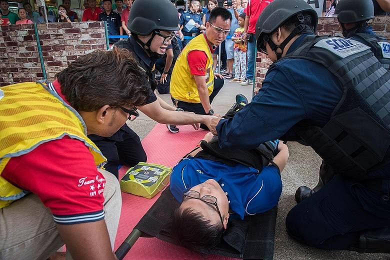 Singapore Civil Defence Force (SCDF) officers attending to a "victim", following a drill simulating an attack by gunmen yesterday. Shots had rung out earlier in Jurong West, as gunmen attacked the Sunday morning crowd at a market. Fortunately, it was