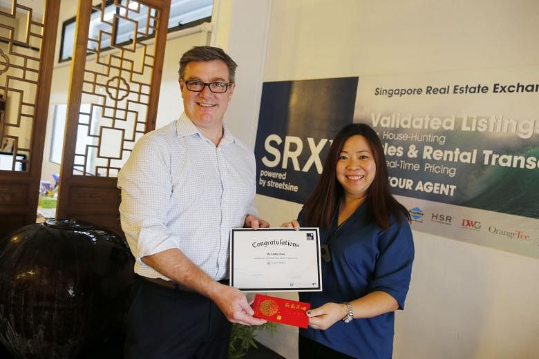 Home owner Emily Chua receiving a certificate and a cash prize of $888 yesterday from Mr Jason Barakat-Brown, chief executive of StreetSine Technology Group, which owns the SRX Property portal that offers the mySG Home service.