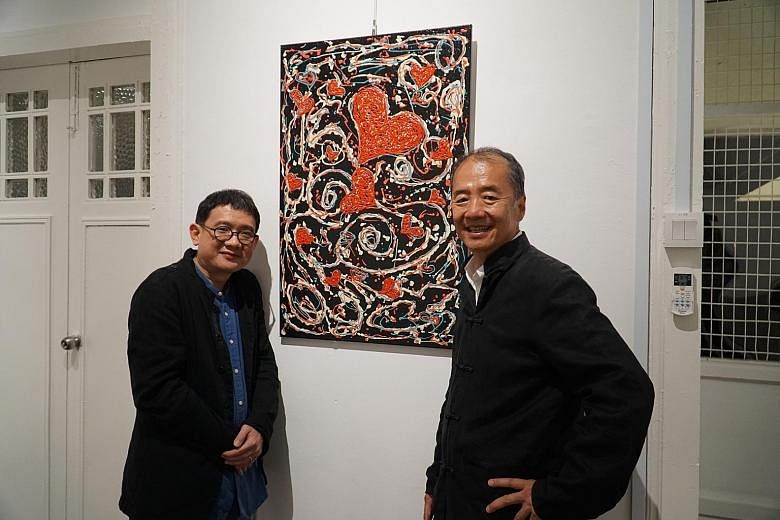 Mr Phan Ming Yen (left), director of non-profit organisation Global Cultural Alliance, and artist Sun Yu Li, with one of the inmates' art works on display at arts centre Temenggong House 18/20.